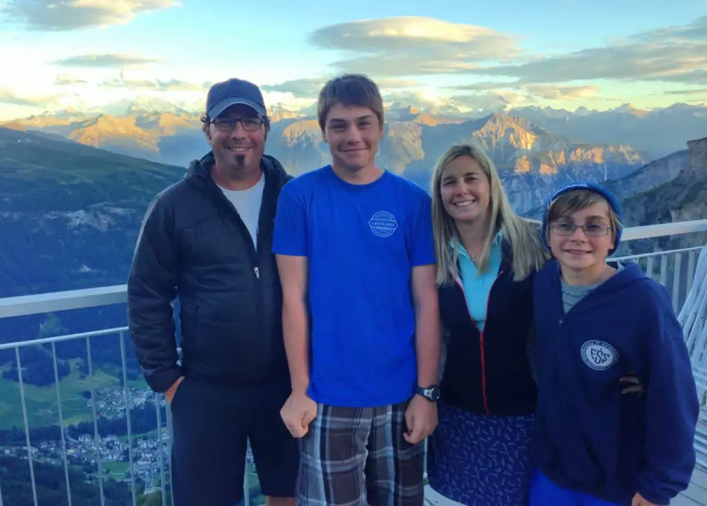 family of four posing in front of swiss alps
