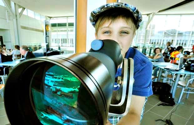 kid looking into telescope