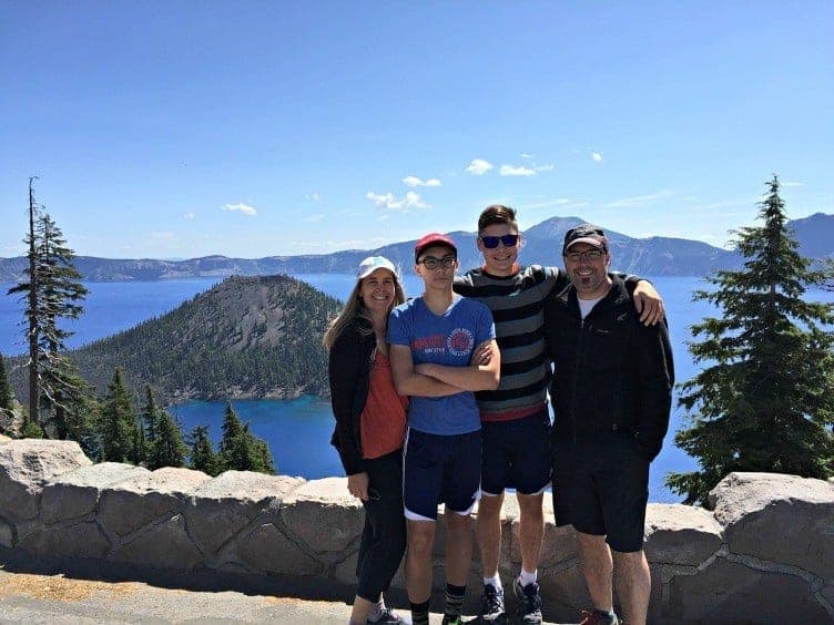 family of four posting at crater lake showing that family travel matters