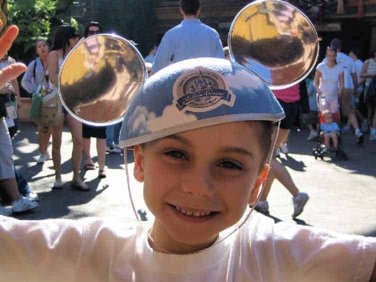 happy boy wearing mouse ears at disneyland