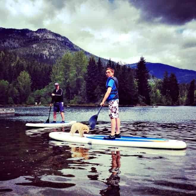 boy and dog on stand up paddle board in whistler with kids