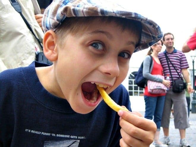 boy eating fry in bruges belgium