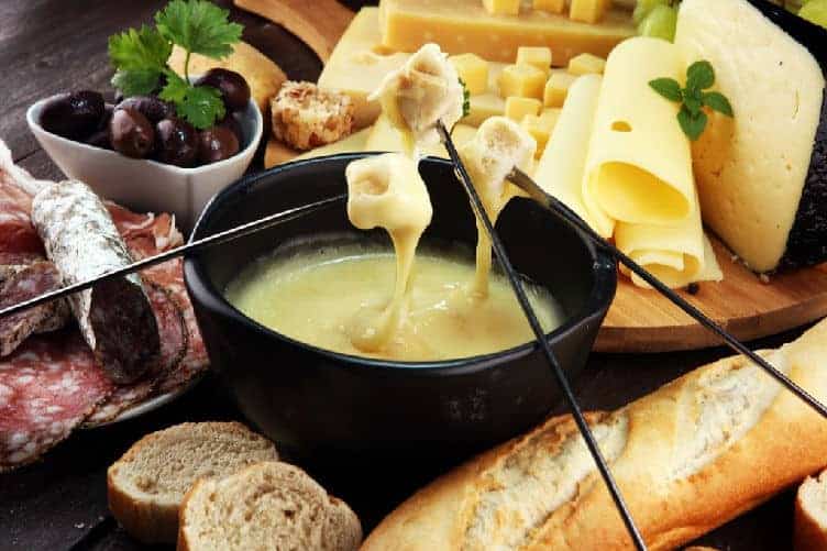 cubes of bread dipped into swiss cheese fondue