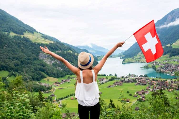 lady with swiss flag overlooking mountains
