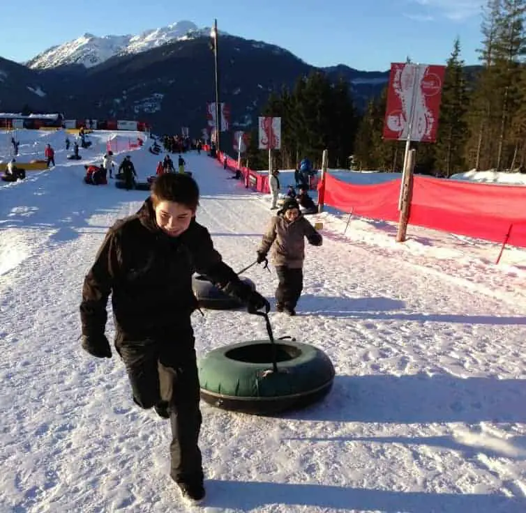 two kids pulling tubes in whistler in winter
