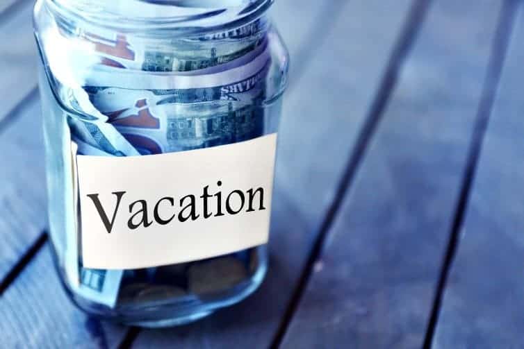filling a glass jar with money to save for travel is a fun travel hack