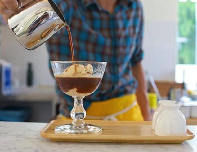 man pouring coffee over ice cream