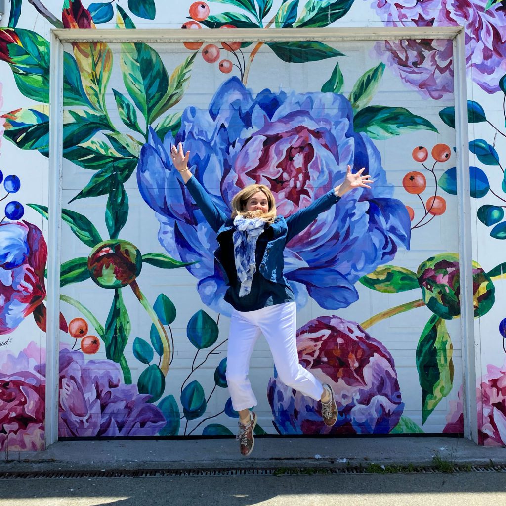 lady jumping in front of yarmouth mural