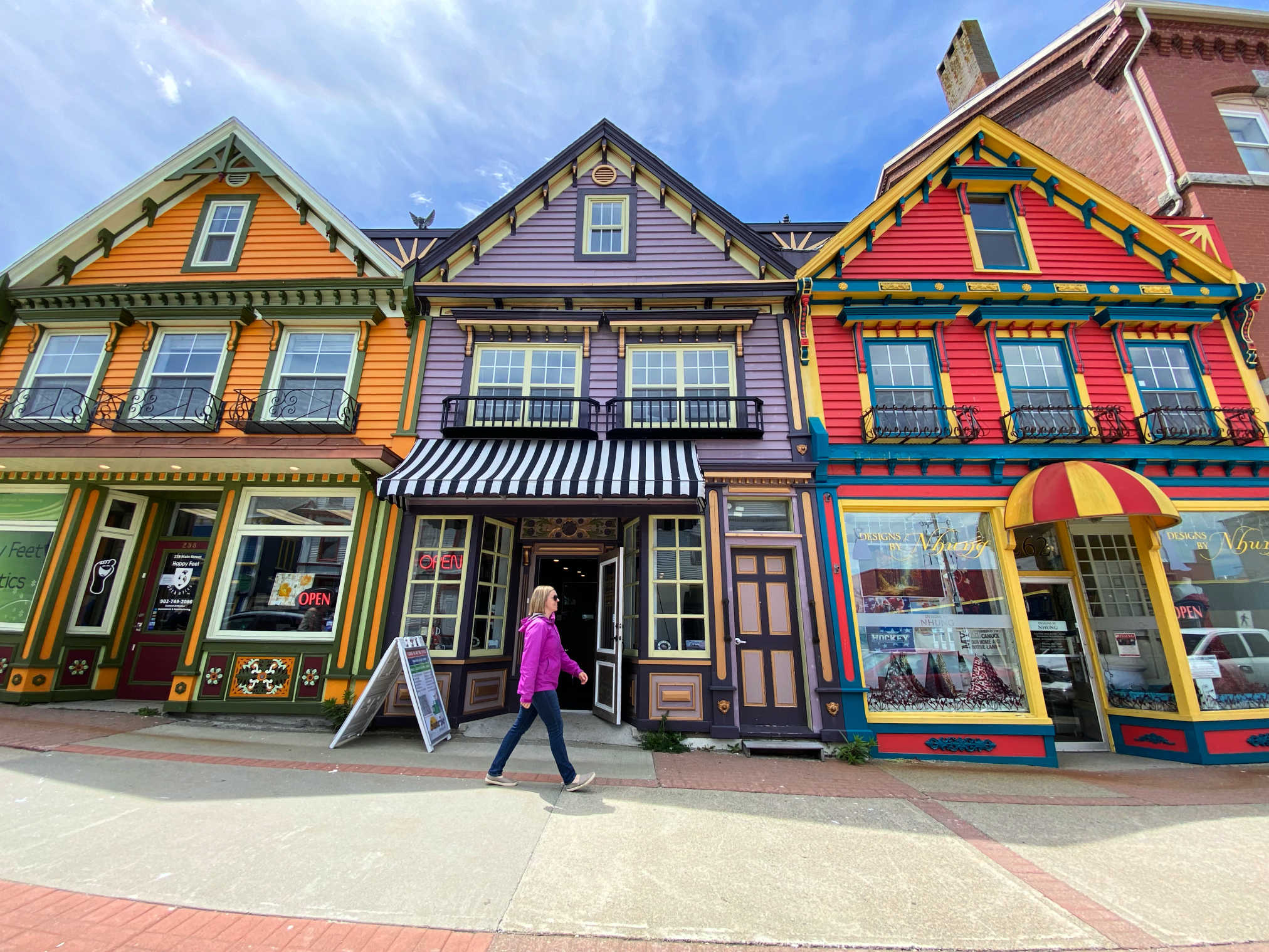 lady walking in front of colorful houses