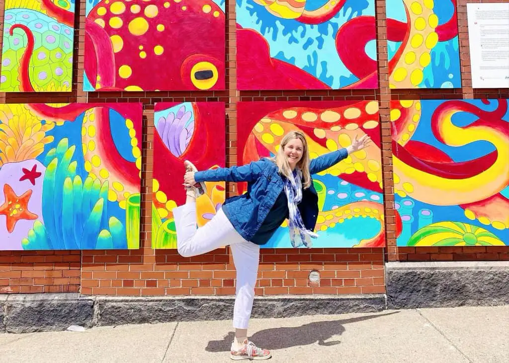 lady doing yoga in front of mural in yarmouth