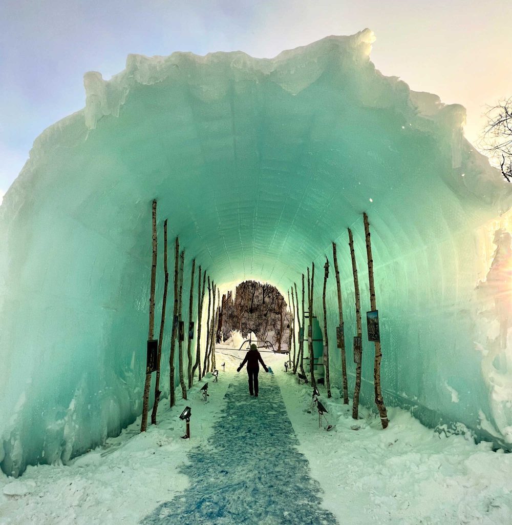 person standing in ice blue tunnel at Shikotsuko ice festival