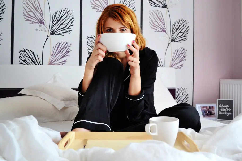 lady drinking soup in bed
