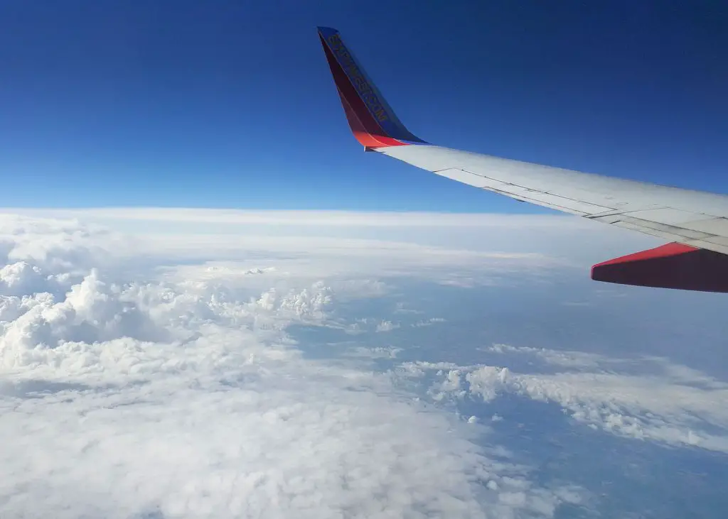 airplane wing in the sky flying travel hacks