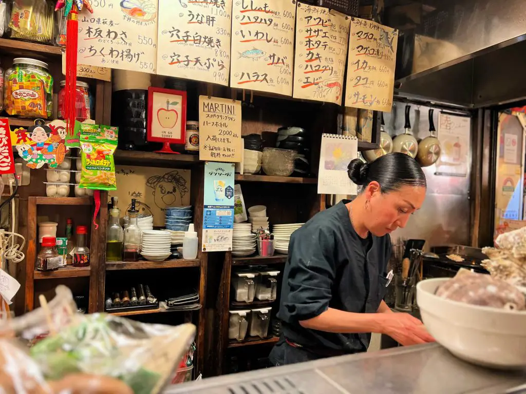 lady preparing food in small bar tokyo