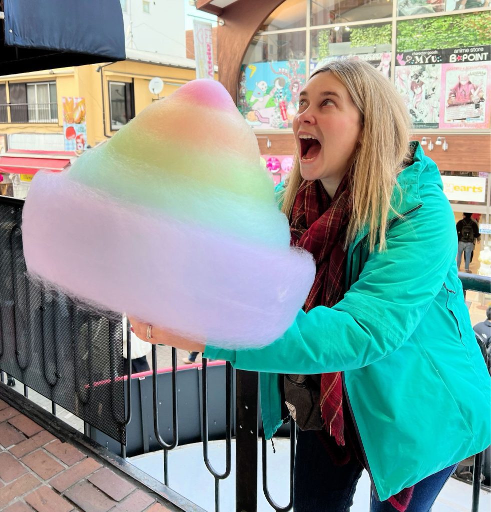 girl eating giant rainbow cotton candy