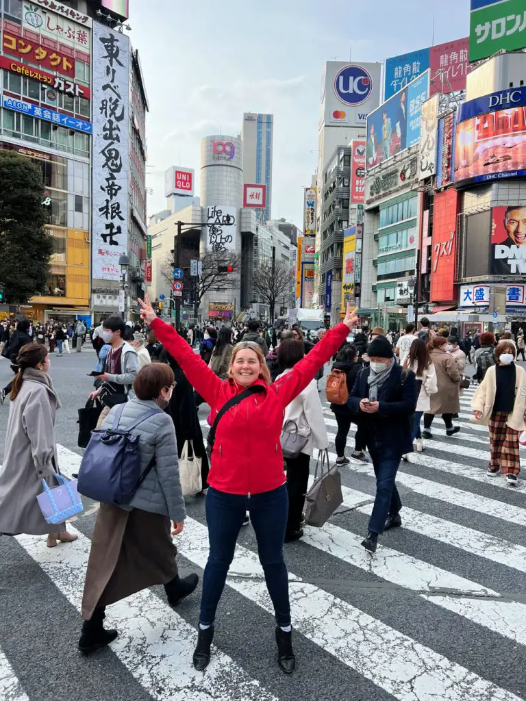 lady in red coat at shibuya  crossing tokyo