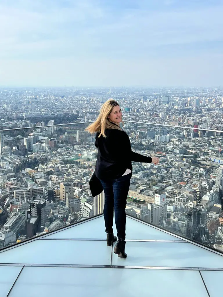 lady on top of shibuya sky with tokyo in background