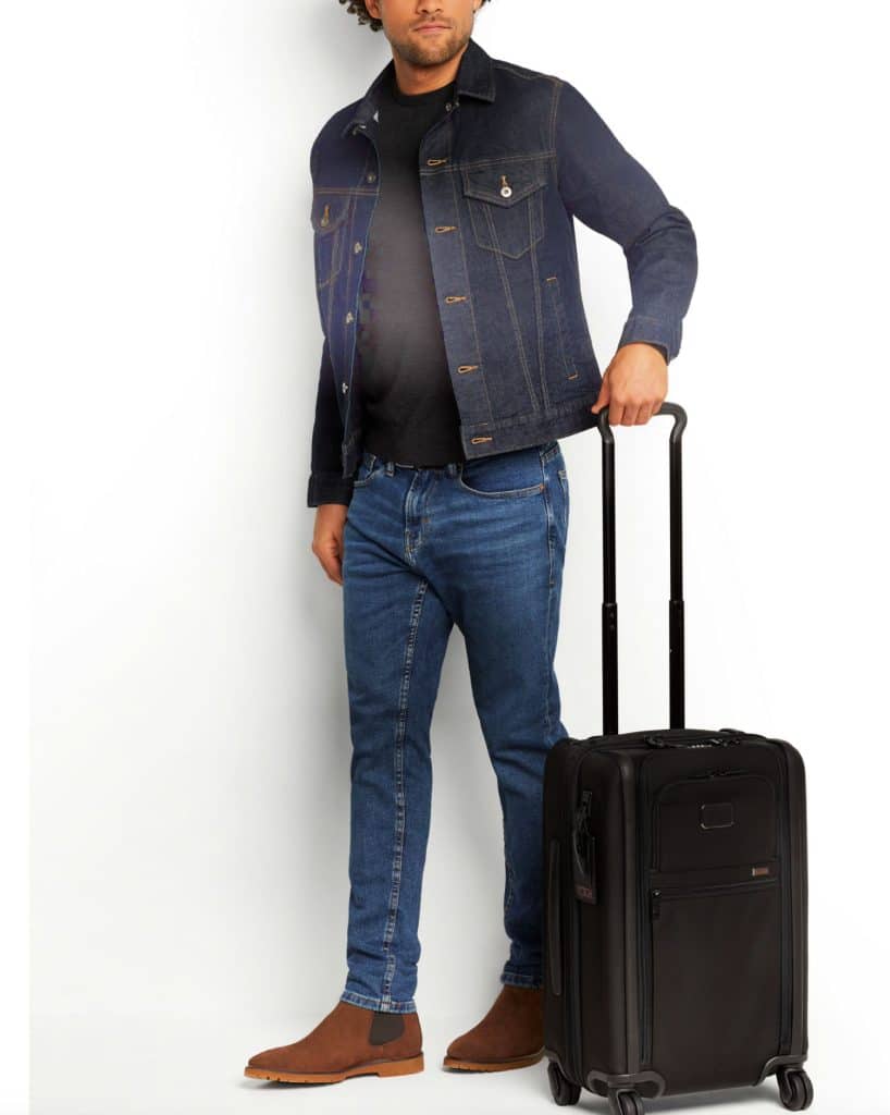 man wheeling black tumi suitcase