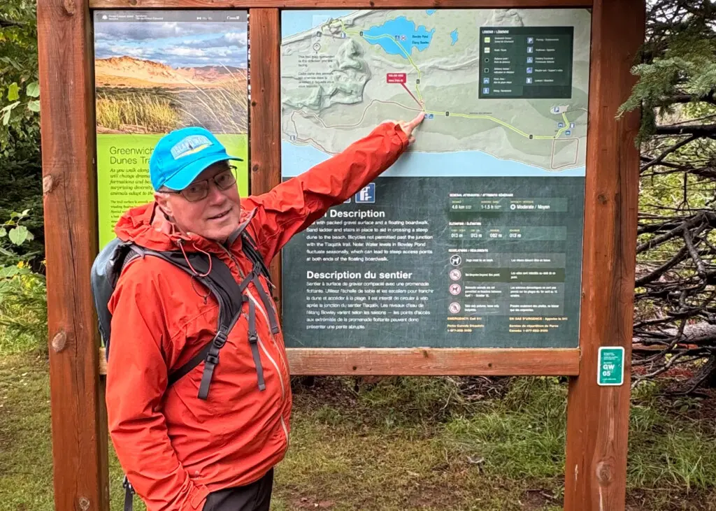 man points to sign at greenwich dunes pei